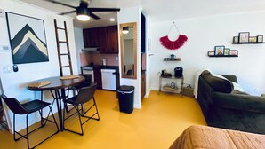A compact living space with a dining area, kitchenette, and seating area. - Color Me Crazy Eclectic Studio with Bay Views! (Daphne)