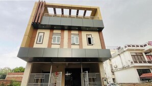 A two-story building with a flat roof, a balcony on the upper floor, and a gated entrance. - Hotel O Taj Holiday  (Agra)