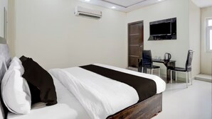 A modern bedroom with a large bed, a desk, and a chair. - Hotel O Taj Holiday  (Agra)