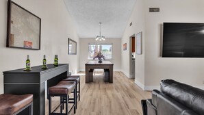 Une cuisine moderne dotée d’un îlot central, de tabourets de bar et d’une table à manger.
