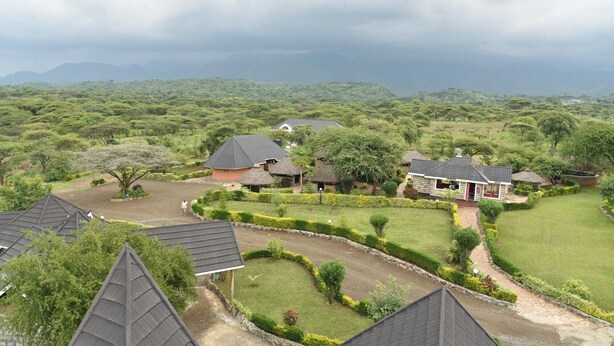 Zona residencial con varias casas, rodeada de abundante vegetación y un paisaje montañoso.