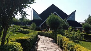 Un sendero de piedra que conduce a un edificio moderno con techo triangular.