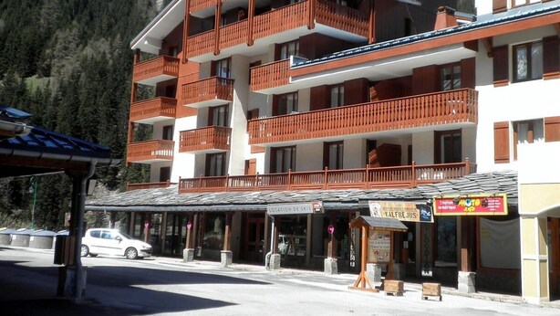 Et hotel med flere etager, altaner, et skilift-skilt og en restaurant i nærheden.