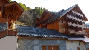 Eine Holzhütte mit mehreren Balkonen und einer Steinaußenwand.