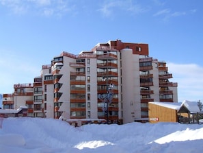 A multi-story hotel with balconies and a ski resort in the background. - 200m from resort center, 3rd floor, tv, 40m², Val Thorens (Val Thorens)