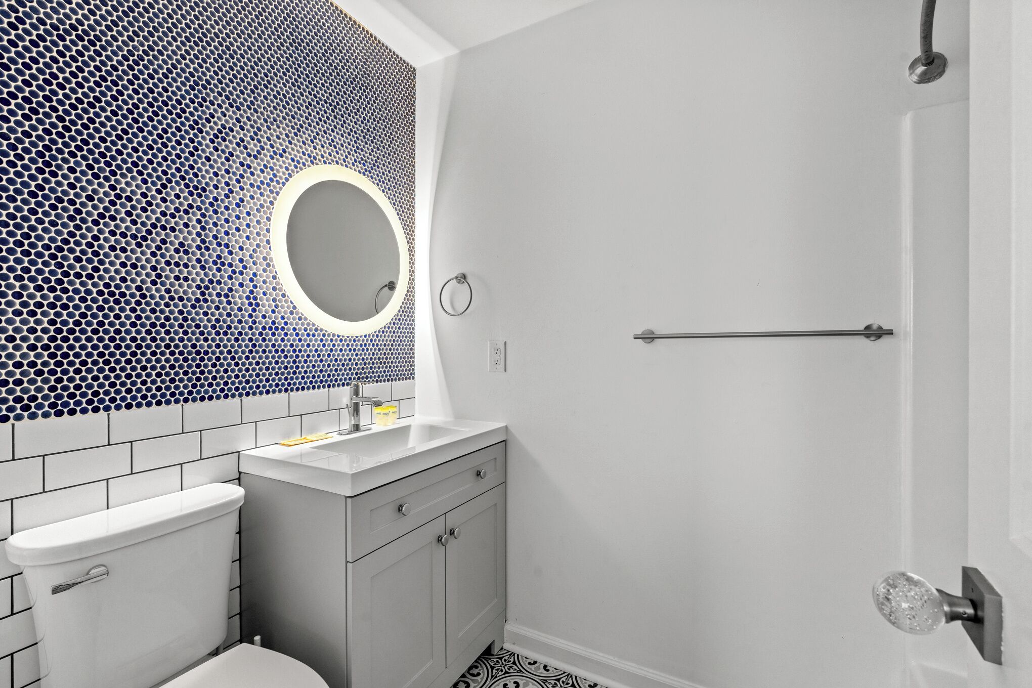 Une salle de bain avec des toilettes, un lavabo et un miroir.