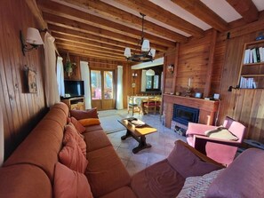 A cozy log cabin interior with a large sofa, a dining area, and a fireplace. - Chalet, 300m from ski slopes, 3rd floor, terrace, fireplace or stove, tv, 205m², Montgenèvre (Montgenèvre)