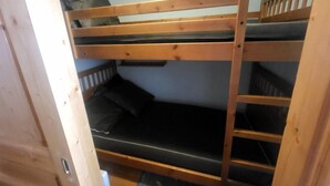 A bunk bed room with wooden railings and a small shelf above the lower bunk. - 300m from ski slopes, Ground floor, view parking, terrace, parking, tv, ski locker, 29m² (Montgenèvre)