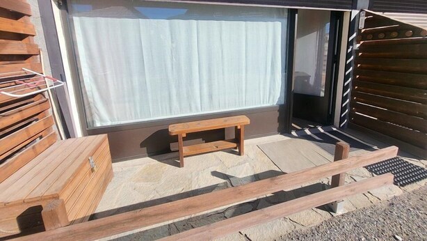 A wooden bench outside a building with a large window and a closed shutter. - 300m from ski slopes, Ground floor, view parking, terrace, parking, tv, ski locker, 29m² (Montgenèvre)