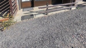 A building with a sliding glass door, a wooden bench, and a metal grate on the ground. - 300m from ski slopes, Ground floor, view parking, terrace, parking, tv, ski locker, 29m² (Montgenèvre)