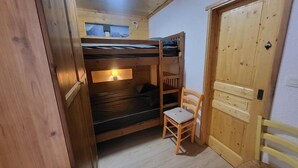 A compact room with a bunk bed, a small table, and a chair. - 300m from ski slopes, Ground floor, view parking, terrace, parking, tv, ski locker, 29m² (Montgenèvre)
