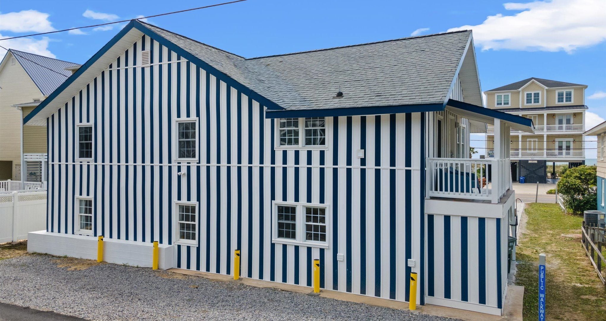 A two-story building with a gabled roof and a balcony on the second floor.