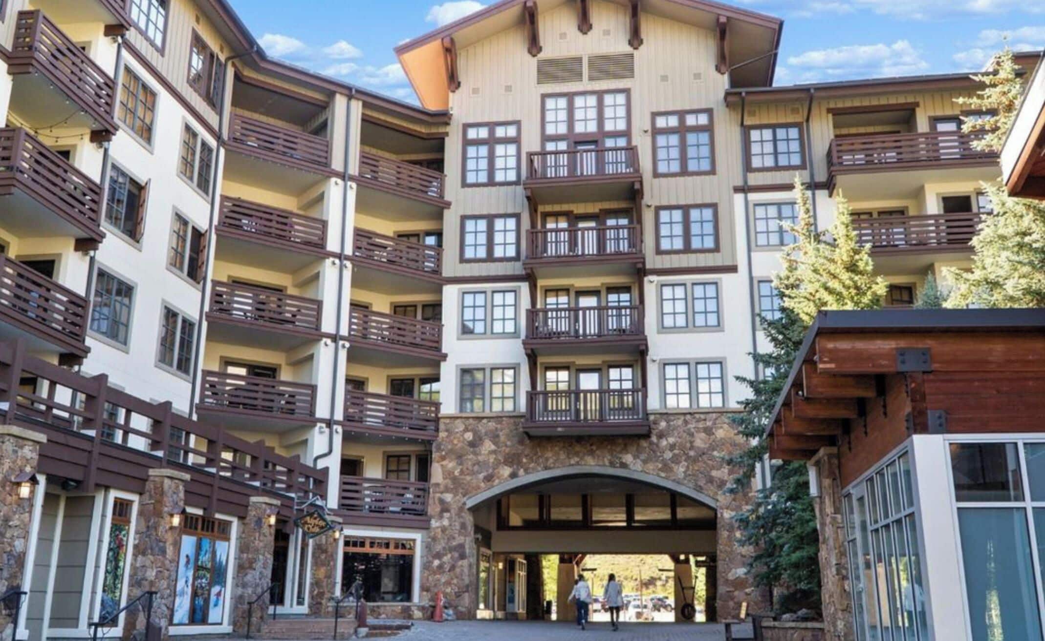 Ein mehrstöckiges Hotel mit Balkonen, einer Steinfassade und einem zentralen Eingang.