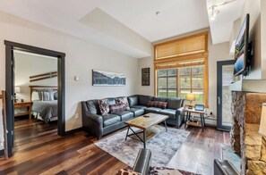 Ein modernes Wohnzimmer mit einem Ecksofa, einem Couchtisch und einem Kamin.