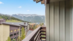 Ein Balkon mit Blick auf ein Gebirge und Gebäude.