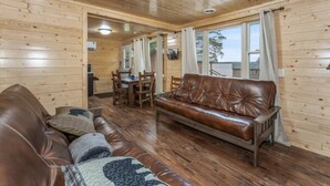 Ein Holzinterieur mit einer Ledersofa, einem Esstisch und Stühlen.