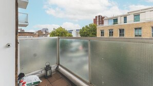 Un balcone con vista su edifici vicini e cielo sereno.