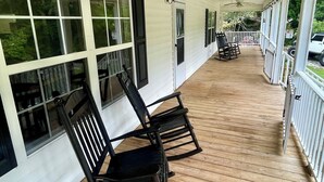 A covered porch with wooden flooring, white railings, and two rocking chairs. - Etowah Valley Ranch - Peaceful, private, and serene!  CLose to everything! (Dahlonega)