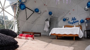 A tented room with a bed, pillows, and a bench. - Glamping el Jade (San Francisco)