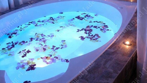 A spa bath with a water feature and candles. - Glamping el Jade (San Francisco)