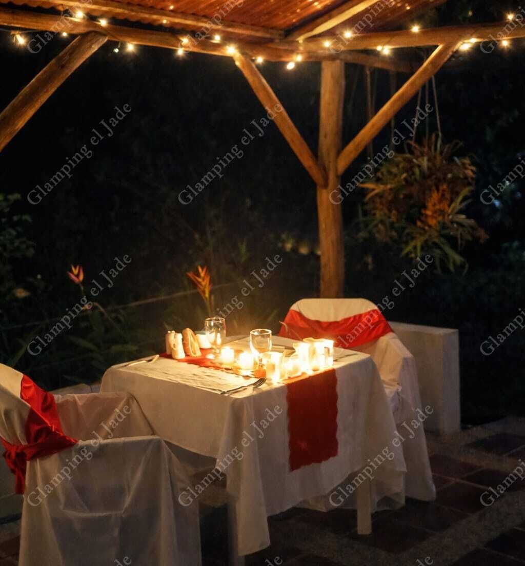An outdoor dining area with tables set for two, covered with white tablecloths and red sashes, under a wooden pergola with string lights.