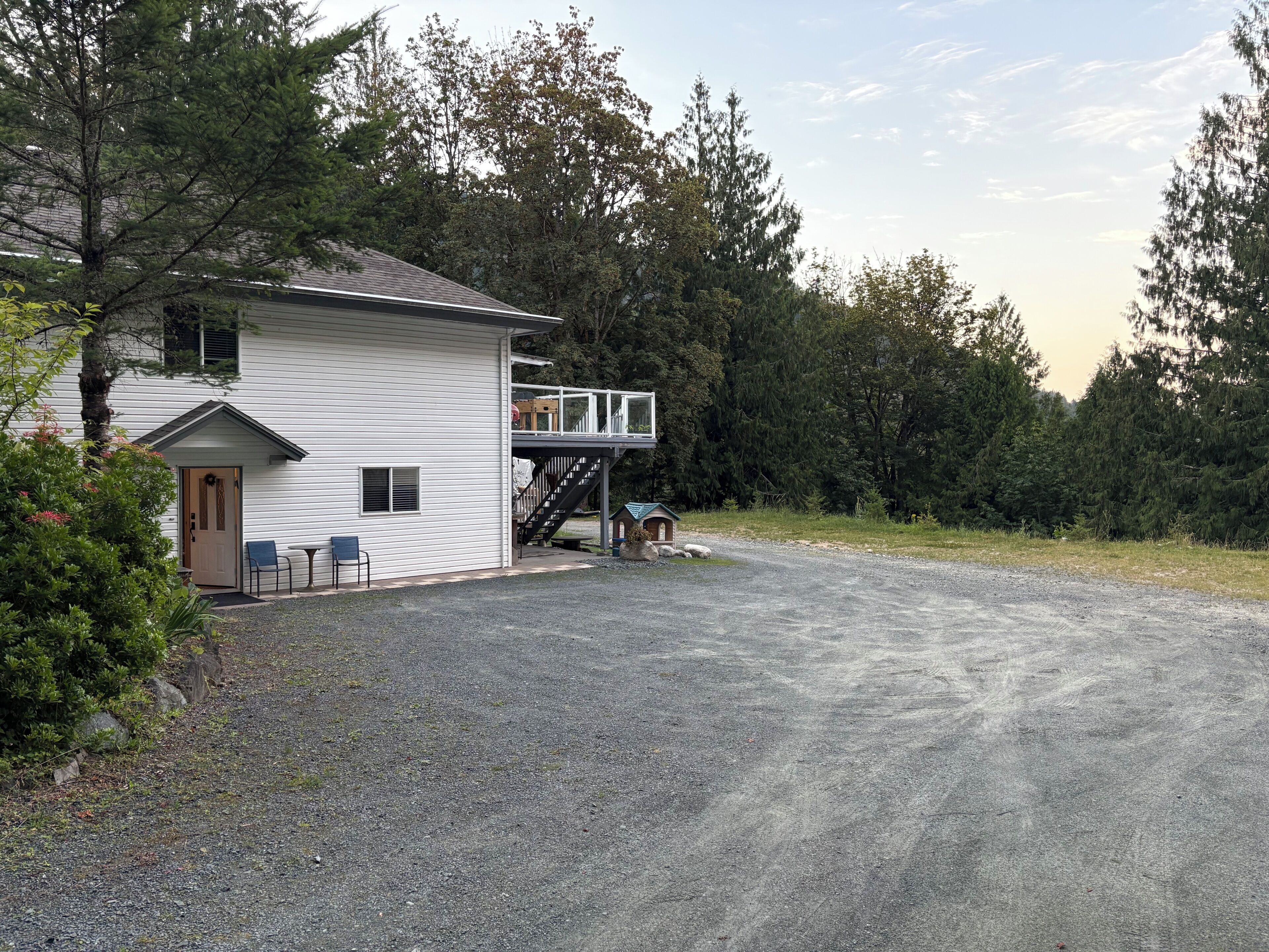 Une maison à deux étages avec un porche et une allée gravillonnée.