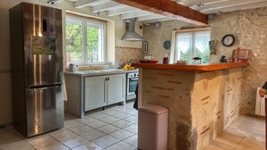 A kitchen with a stainless steel refrigerator, a sink, a stove, and a trash bin. - Maison de campagne à Aiguillon, Garden, Terrace, Game room, No pets allowed (Aiguillon)
