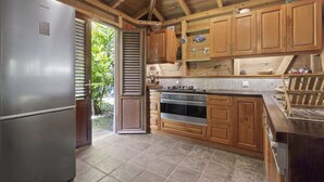 Una cocina con armarios de madera, un refrigerador de acero inoxidable y salpicadero de azulejos.