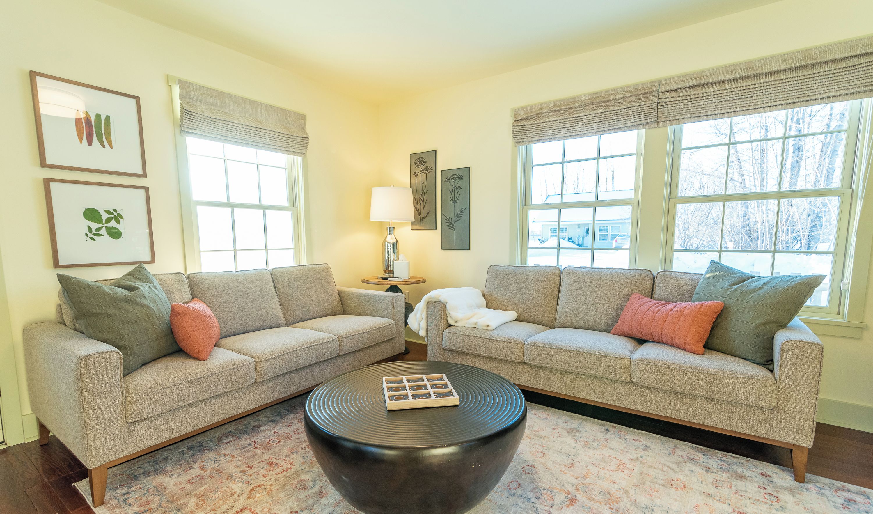 A living room with two sofas, a coffee table, and a lamp.