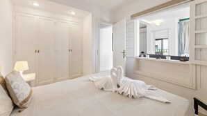 A hotel room with a bed, a large mirror, a wardrobe, and a window with curtains.
