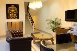 Ein modernes Wohnzimmer mit einer Couch, einem Couchtisch und einer Buddha-Statue.