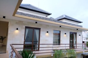 A modern two-story house with a balcony, large windows, and a stone facade. - VIlla Avi (Bali)