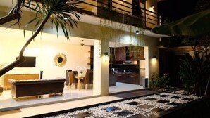 A modern two-story house with a dining area, kitchen, and a balcony with plants. - VIlla Avi (Bali)