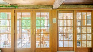 A wooden door with glass panels, a sign reading "Welcome to the Lodge," and a view of outdoor seating and chairs. - Country home in beautiful Bucks County (Hatfield)