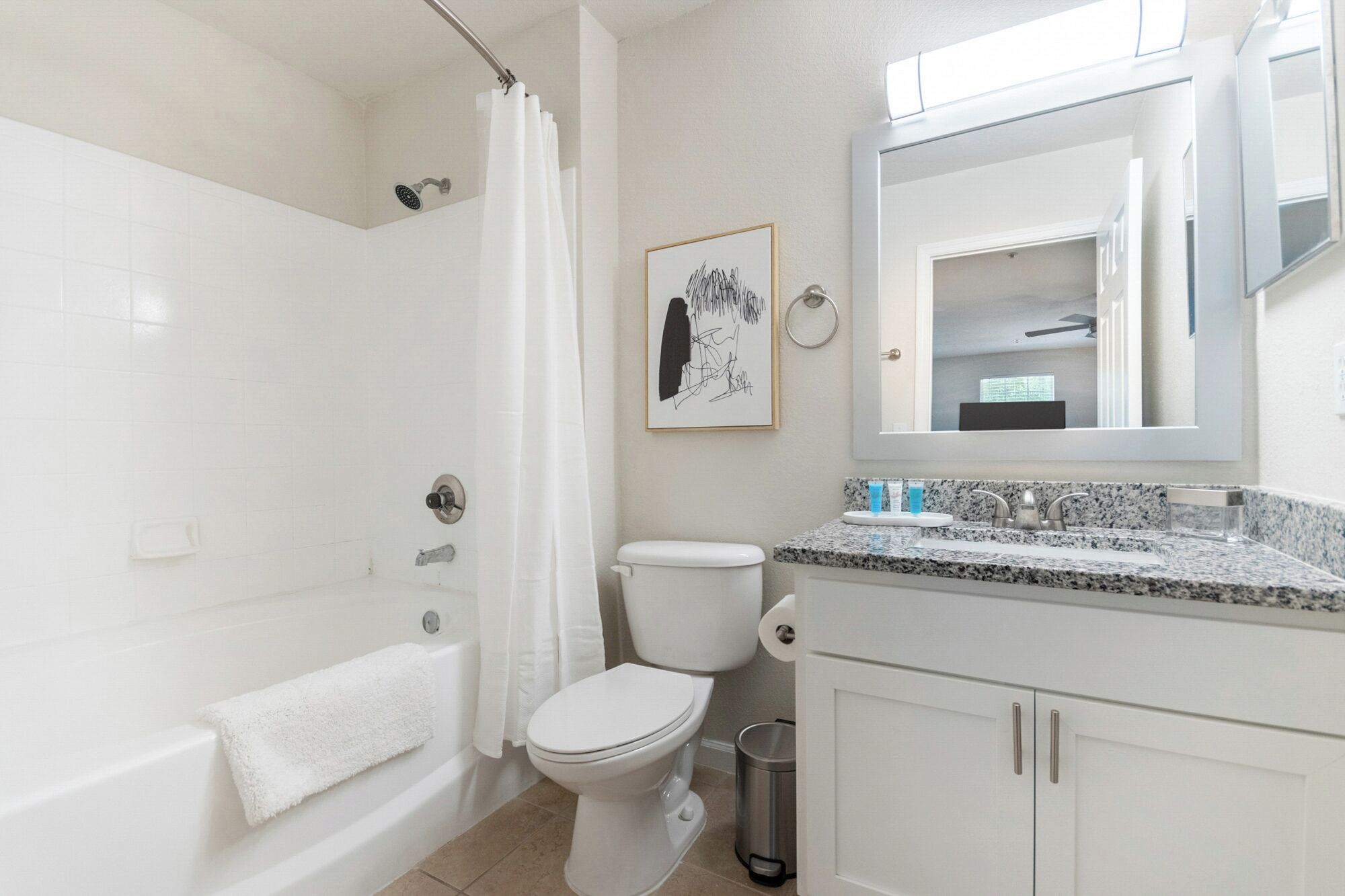 Een moderne badkamer met bad, toilet en wastafel.