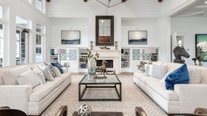 A spacious living room with two sofas, a coffee table, and a fireplace. - Landing Apartments Charleston - Summerville (Summerville)