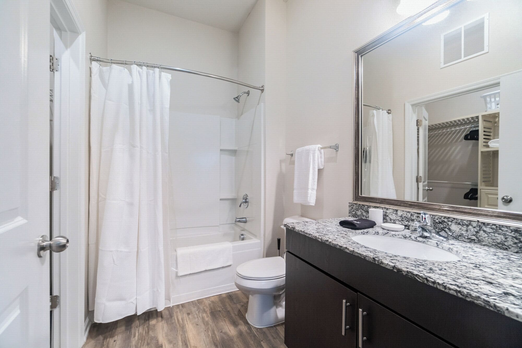 A bathroom with a shower, toilet, and sink.