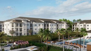 Un hotel de varios pisos con piscina, mobiliario exterior y palmeras.