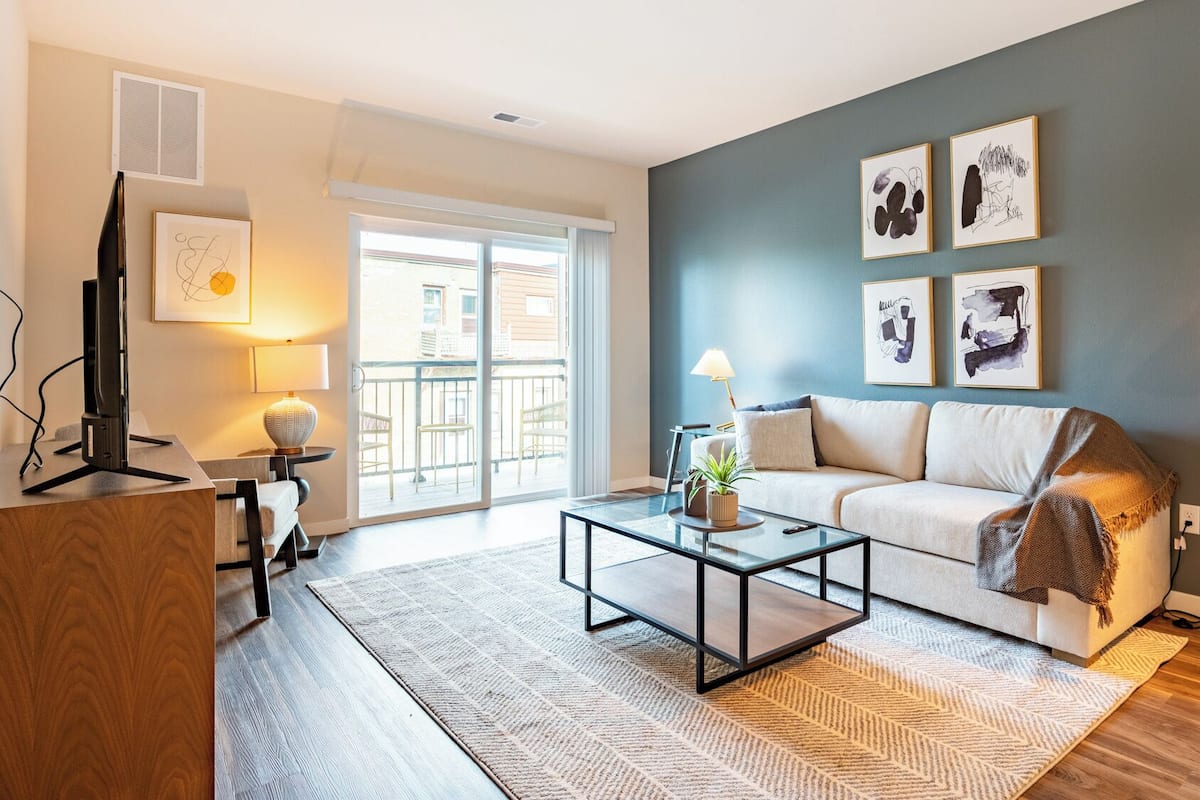 A modern living room with a sofa, coffee table, and artwork on the wall.