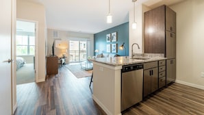 A modern kitchen with a built-in island, stainless steel appliances, and a view to the living area.