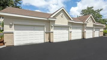 A row of three attached garages with a single garage door on each.