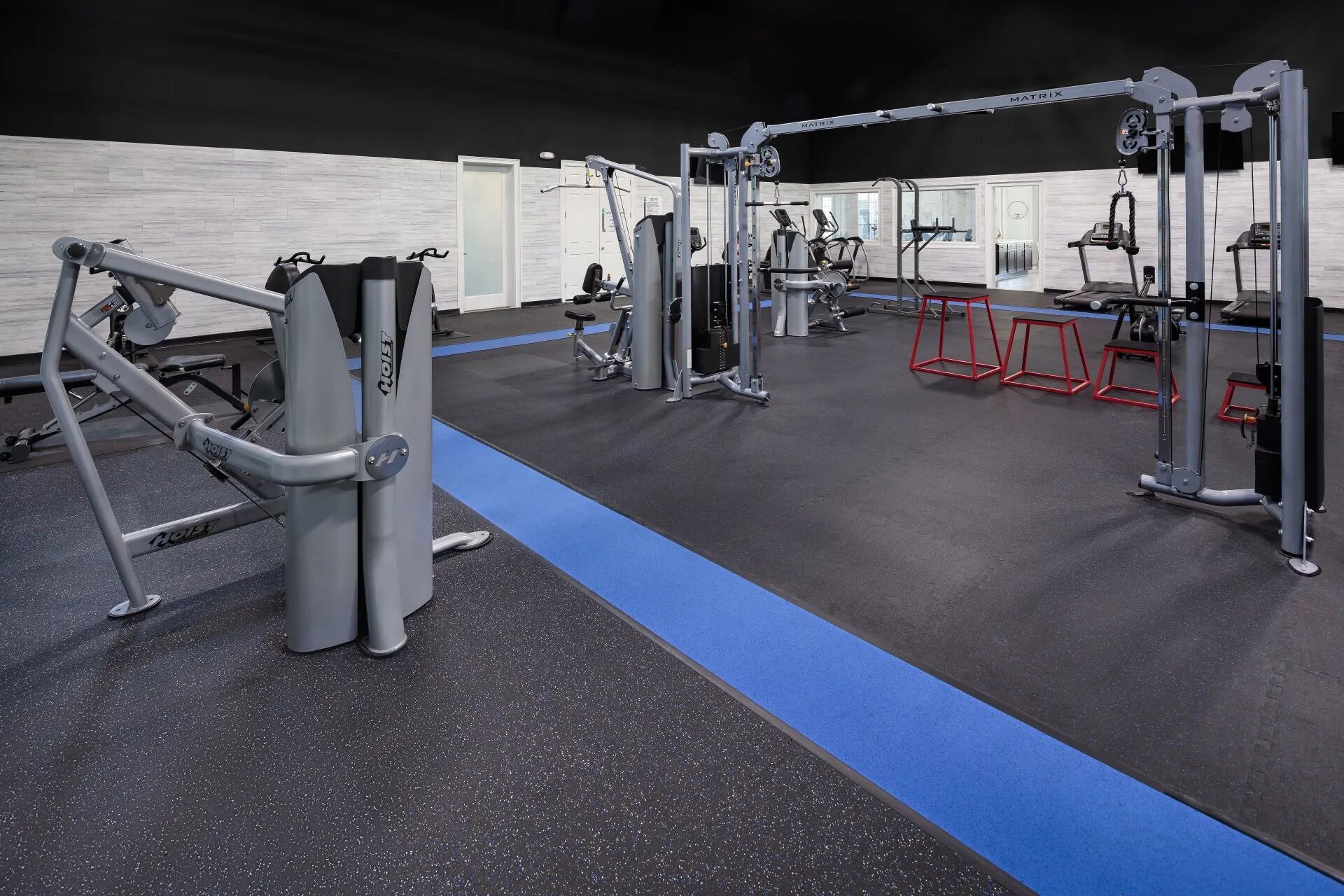 A gym with various exercise equipment, including weight machines and free weights.
