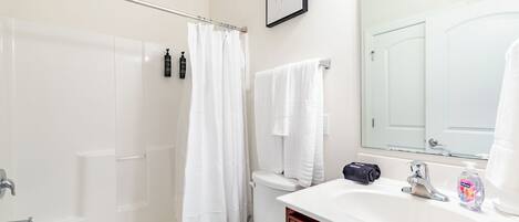 A bathroom with a bathtub, toilet, and sink.