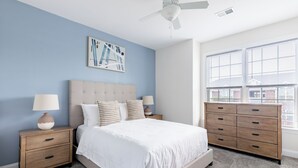 A bedroom with a bed, nightstands, a dresser, and a ceiling fan. - Landing Apartments Myrtle Beach - Carolina Forest (Myrtle Beach)