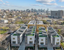 Un complejo de apartamentos moderno con un patio central, rodeado por un paisaje urbano.