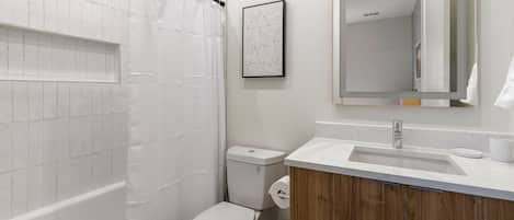 A bathroom with a shower, toilet, and sink.