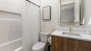 Ein Badezimmer mit Dusche, Toilette und Waschbecken.