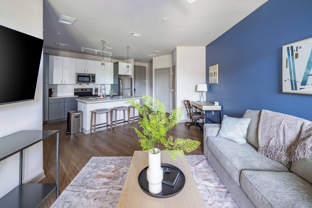 A modern apartment with a kitchen, dining area, and living room.