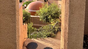 A view through an archway of a building with a dome, a staircase, and a mountainous landscape in the background. - El Oasis - Boutique Mountain Retreat with Pool • 20 mins from Mojácar Beaches (AN)
