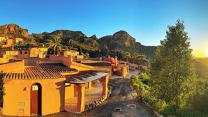 A coastal village with traditional architecture, a clear view of the sea, and a prominent mountain in the background. - El Oasis - Boutique Mountain Retreat with Pool • 20 mins from Mojácar Beaches (AN)